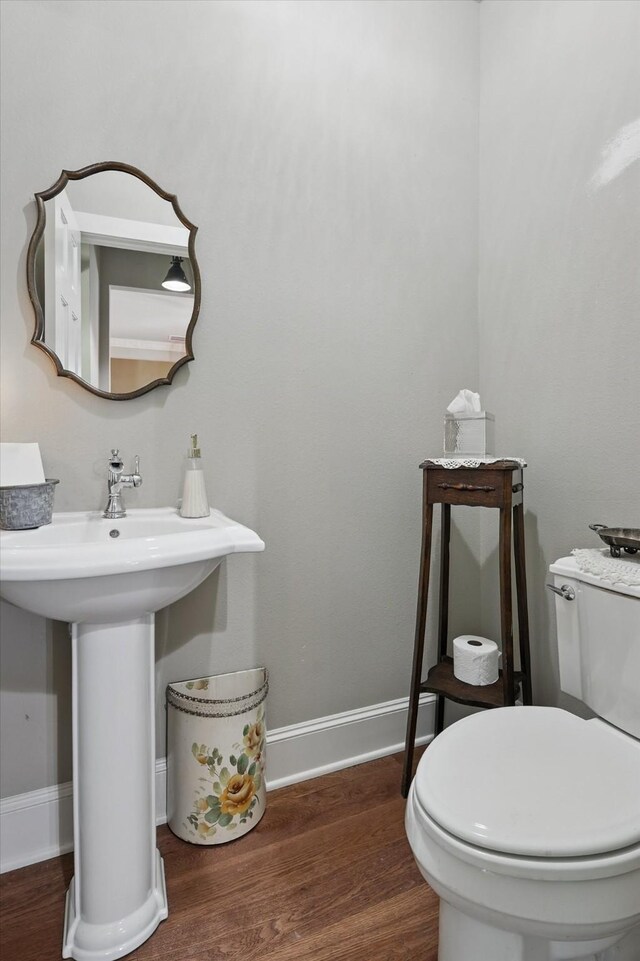 bathroom featuring toilet, baseboards, and wood finished floors