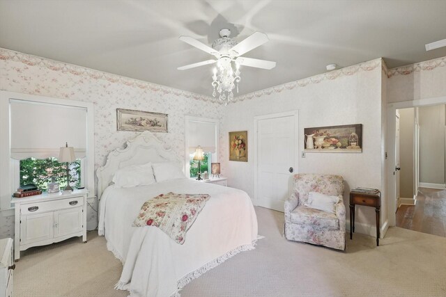 bedroom with wallpapered walls, light carpet, and ceiling fan