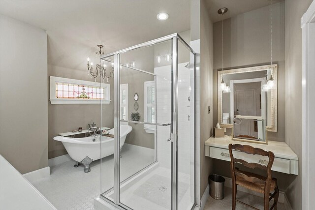 bathroom featuring a freestanding bath, a stall shower, baseboards, tile patterned floors, and a notable chandelier
