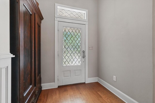 entryway with baseboards and light wood finished floors