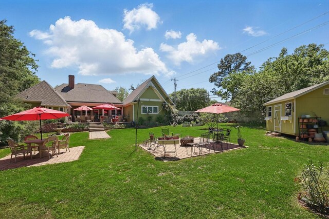 view of yard with a patio area, an outbuilding, and an outdoor fire pit