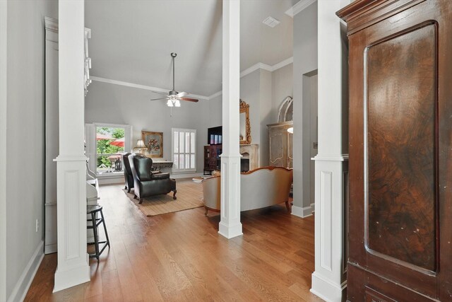 entryway featuring high vaulted ceiling, ceiling fan, ornamental molding, and ornate columns