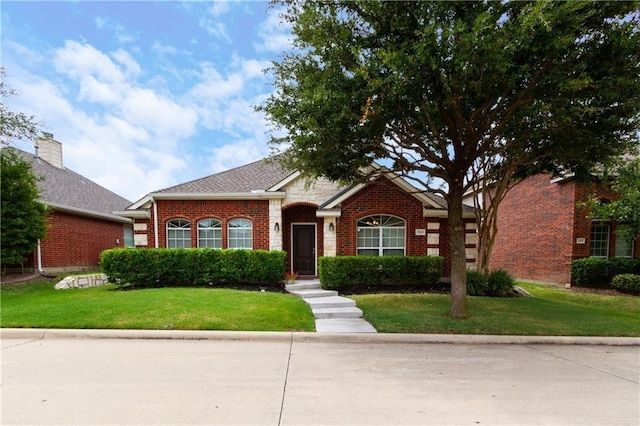 view of front of house featuring a front lawn and brick siding