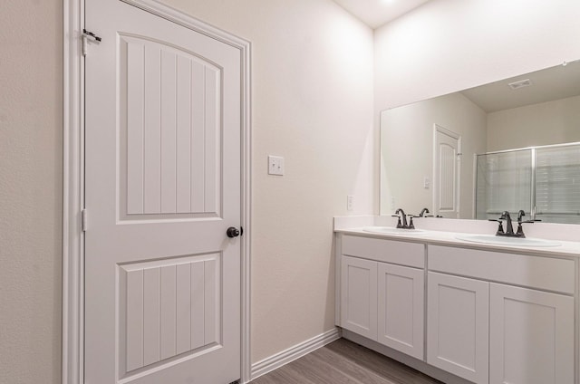 119 Kylie Dr, Cleburne, TX 76031 - full bath with visible vents, double vanity, wood finished floors, a sink, and a shower with shower door