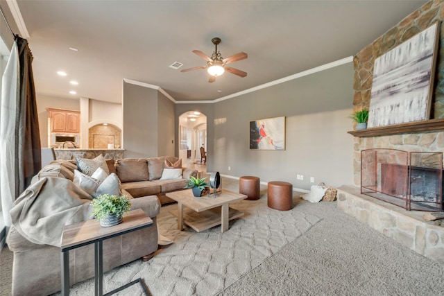 132 Silver Rose Blvd, Burleson, TX 76028 - living area with arched walkways, a stone fireplace, ceiling fan, ornamental molding, and carpet floors