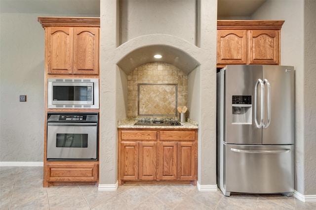 132 Silver Rose Blvd, Burleson, TX 76028 - kitchen featuring appliances with stainless steel finishes, light stone countertops, baseboards, light tile patterned floors, and a textured wall