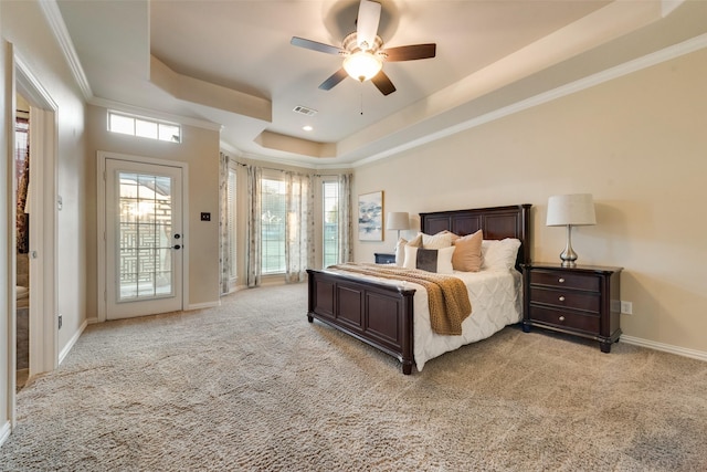 bedroom with a raised ceiling, visible vents, light carpet, and access to exterior