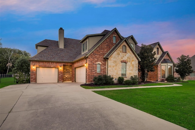 view of front of property featuring fence, a front yard, a chimney, an attached garage, and driveway
