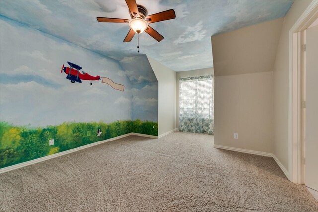 carpeted spare room featuring baseboards and a ceiling fan