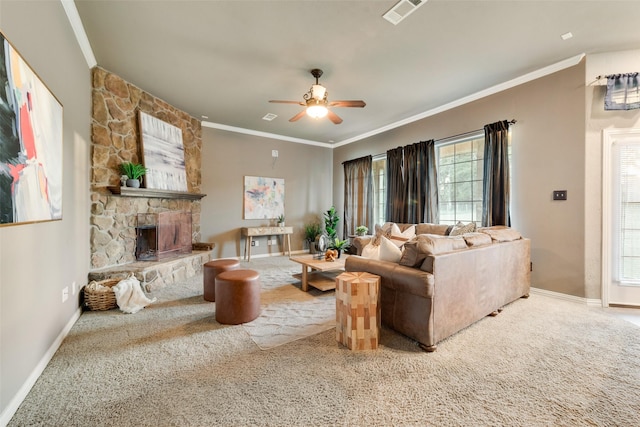 carpeted living area featuring visible vents, a ceiling fan, crown molding, and a fireplace