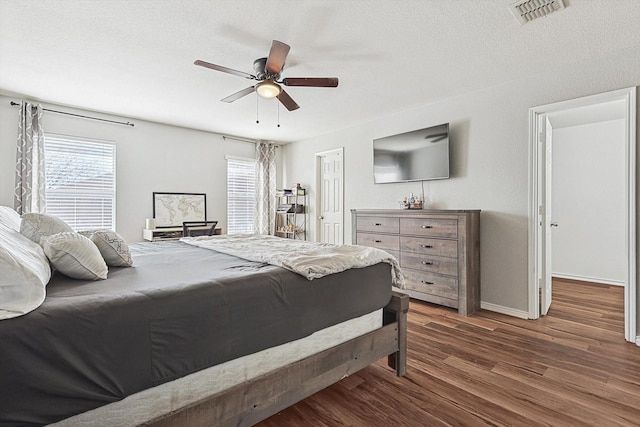1225 Bellevue Dr, Princeton, TX 75407 - bedroom featuring ceiling fan, a textured ceiling, baseboards, wood finished floors, and visible vents