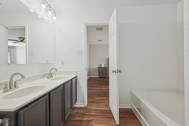 1225 Bellevue Dr, Princeton, TX 75407 - full bathroom with a ceiling fan, visible vents, a sink, and wood finished floors
