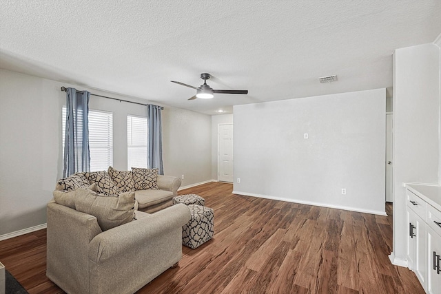 1225 Bellevue Dr, Princeton, TX 75407 - living room featuring visible vents, a ceiling fan, baseboards, and dark wood-style flooring