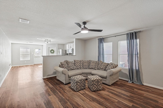 1225 Bellevue Dr, Princeton, TX 75407 - living room with a textured ceiling, dark wood finished floors, a ceiling fan, baseboards, and visible vents