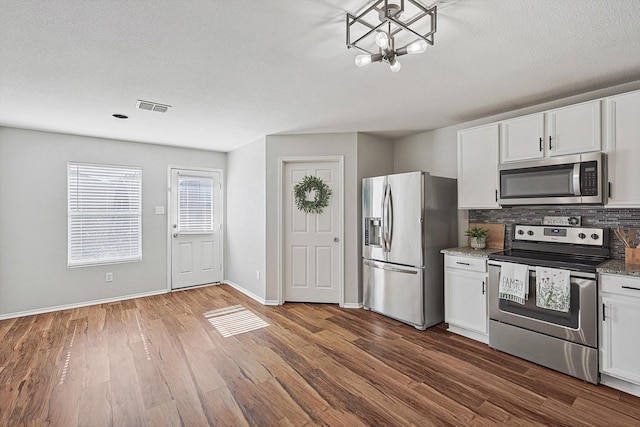 1225 Bellevue Dr, Princeton, TX 75407 - kitchen featuring backsplash, visible vents, white cabinets, dark wood-style floors, and stainless steel appliances