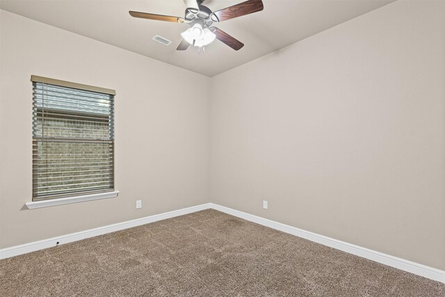 spare room with baseboards, a ceiling fan, carpet flooring, and visible vents