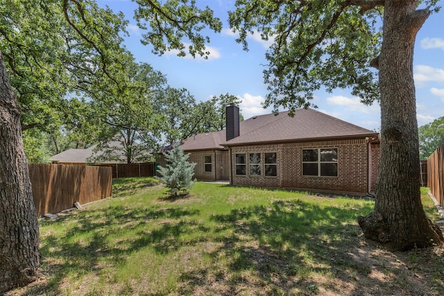 308 Donna Cir, Granbury, TX 76049 - back of property with a chimney, brick siding, and a shingled roof