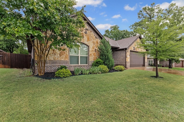 view of front of house featuring a front lawn, fence, stone siding, brick siding, and an attached garage