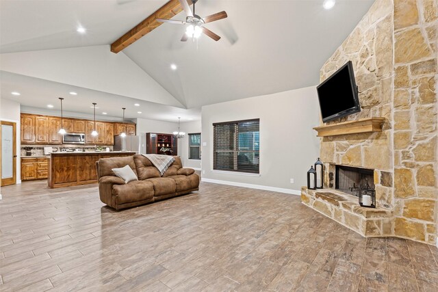 living area with beam ceiling, a stone fireplace, ceiling fan, recessed lighting, and light wood-type flooring