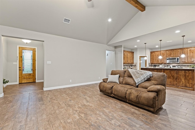 living area featuring recessed lighting, light wood-type flooring, baseboards, and beamed ceiling