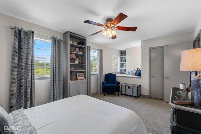 bedroom with a ceiling fan and light colored carpet