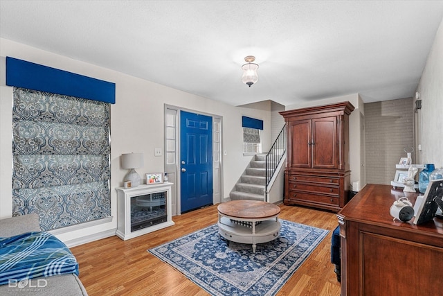 interior space with stairs, baseboards, and light wood-type flooring