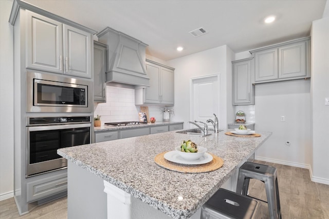 1008 Sublime Dr, Heath, TX 75126 - kitchen featuring light wood-type flooring, a sink, gray cabinetry, and stainless steel appliances