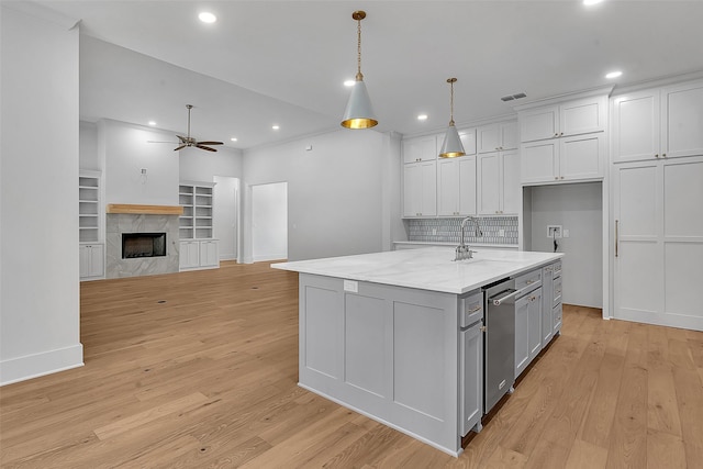 kitchen with ceiling fan, visible vents, a sink, and light wood finished floors