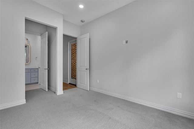 unfurnished bedroom with connected bathroom, recessed lighting, baseboards, and carpet