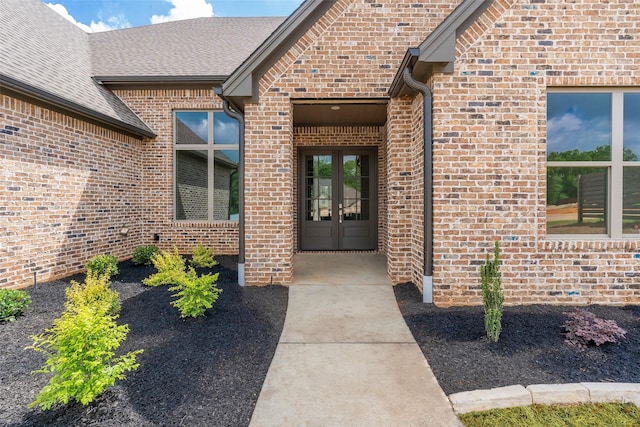 doorway to property featuring french doors and brick siding