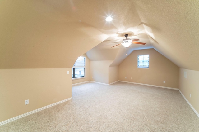 bonus room featuring ceiling fan, vaulted ceiling, light carpet, and baseboards