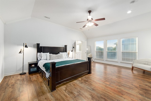 bedroom featuring visible vents, lofted ceiling, wood finished floors, baseboards, and a ceiling fan