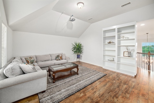 living room with vaulted ceiling, wood finished floors, and visible vents