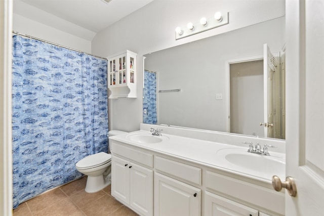full bathroom with a sink, tile patterned floors, toilet, and double vanity