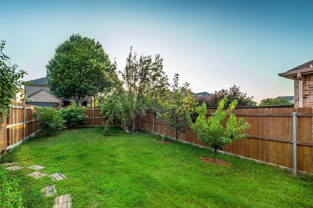 yard at dusk with a fenced backyard