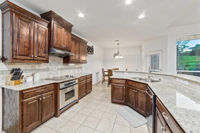 kitchen featuring appliances with stainless steel finishes, tasteful backsplash, a sink, light tile patterned floors, and under cabinet range hood