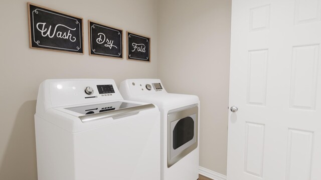 laundry area featuring laundry area, baseboards, and washer and dryer