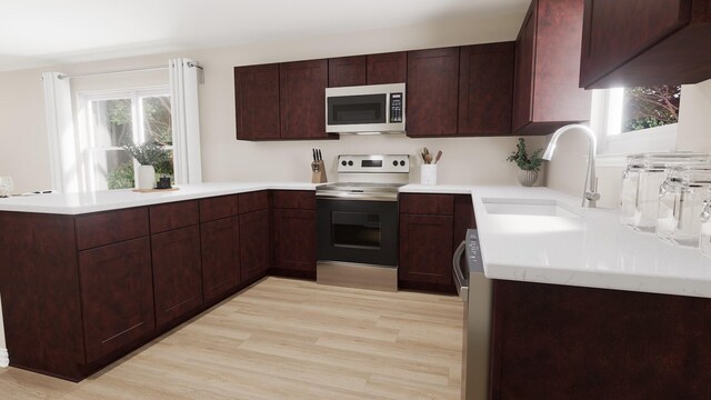 kitchen with electric range, a sink, light countertops, stainless steel microwave, and a peninsula