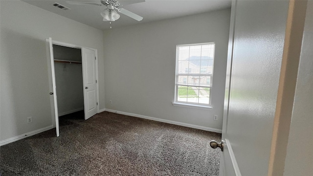 unfurnished bedroom with visible vents, baseboards, and dark carpet