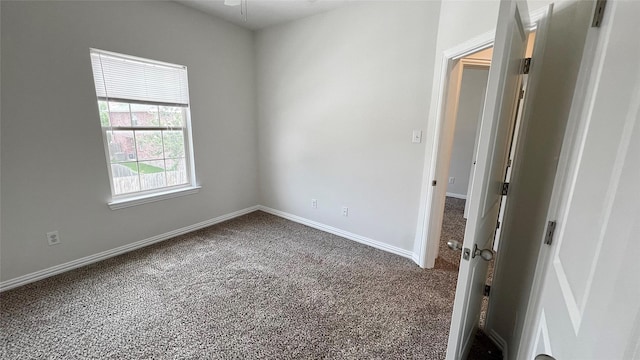 carpeted empty room with baseboards and ceiling fan
