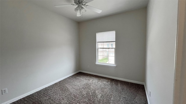 unfurnished room with baseboards, ceiling fan, and dark colored carpet