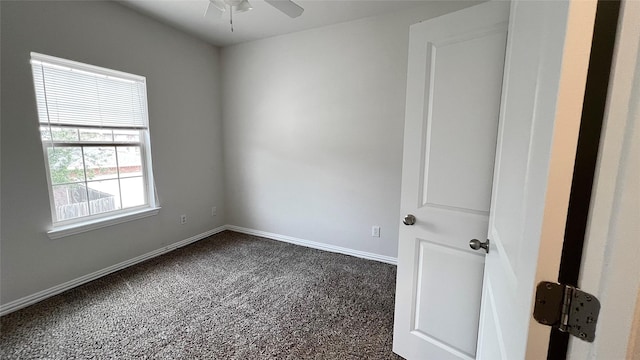 empty room with baseboards, ceiling fan, and dark carpet