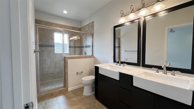 full bath featuring double vanity, toilet, a shower stall, and a sink