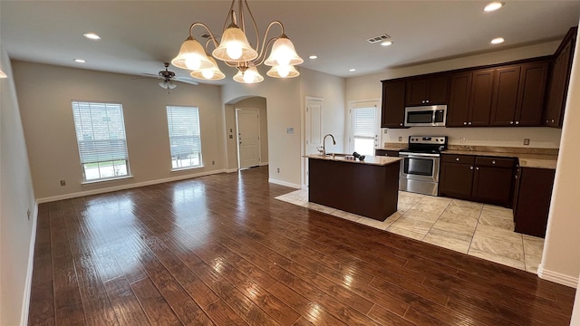 kitchen featuring arched walkways, ceiling fan with notable chandelier, stainless steel appliances, open floor plan, and visible vents