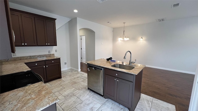 kitchen with dark brown cabinets, a sink, dishwasher, arched walkways, and baseboards