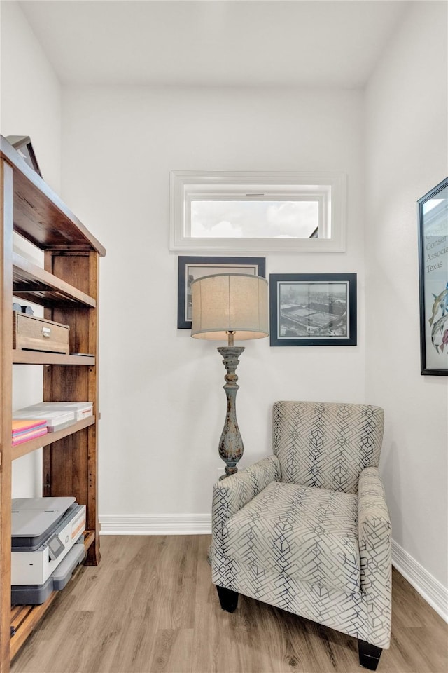 living area featuring baseboards and wood finished floors