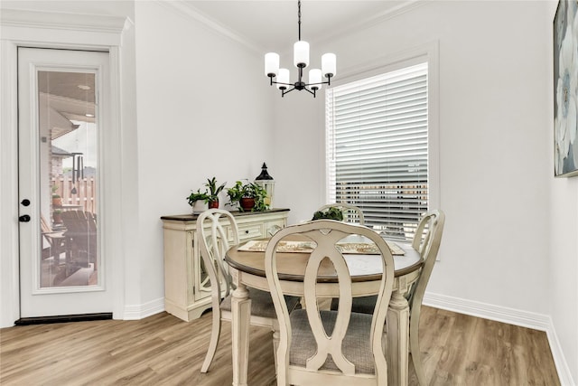 dining area with baseboards, a wealth of natural light, light wood finished floors, and a chandelier