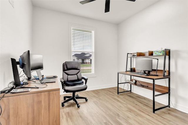 home office with baseboards, a ceiling fan, light wood finished floors, and a healthy amount of sunlight