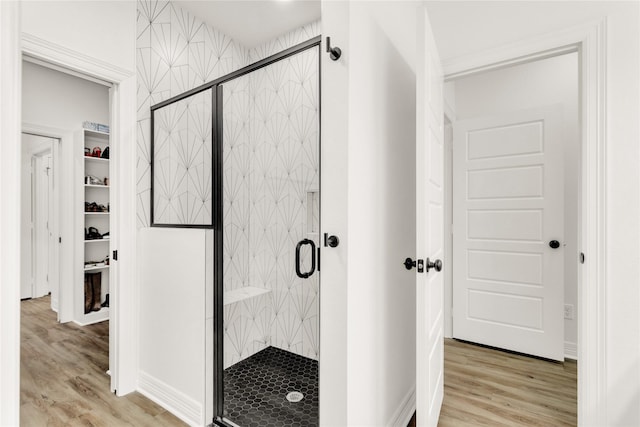 bathroom featuring wood finished floors and a shower stall