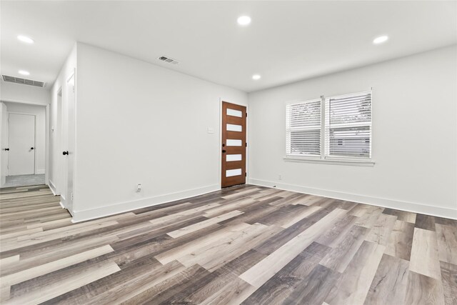 empty room featuring visible vents, recessed lighting, and wood finished floors